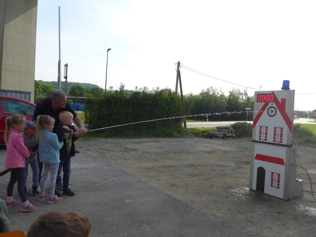 Kinder spritzen mit Feuerwehrschlauch