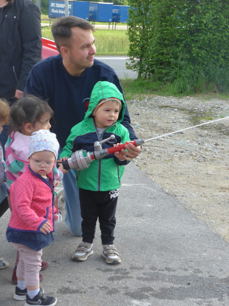 Kinder halten Feuerwehrschlauch