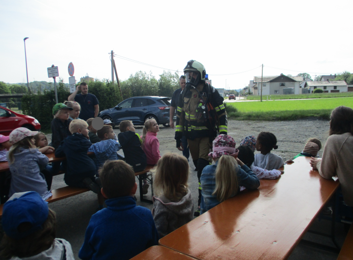 Feuerwehrmann steht vor Kinder